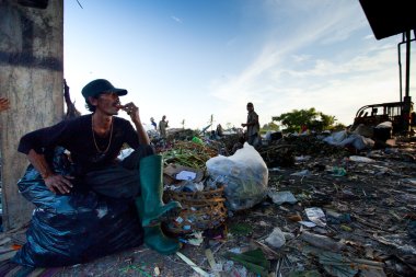 BALI, INDONESIA  APRIL 11: Poor from Java island working in a scavenging at the dump on April 11, 2012 on Bali, Indonesia. Bali daily produced 10,000 cubic meters of waste.